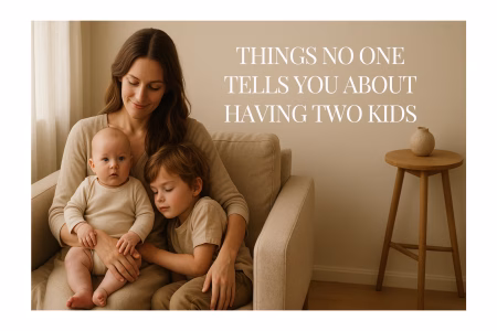 A mother sitting on a sofa with her baby and toddler, sharing a quiet, emotional moment that reflects the reality of having two kids